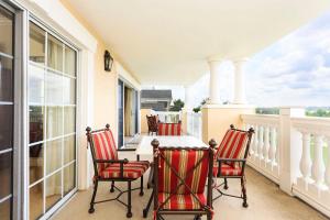 een veranda met stoelen en een tafel op een balkon bij Serenity Apt - Tranquil and Cozy Orlando Apartment in Kissimmee