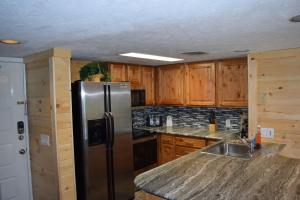a kitchen with a stainless steel refrigerator and wooden cabinets at Eagles View, Luxury living Amazing Mtn Views! indoor pool & spa in Gatlinburg