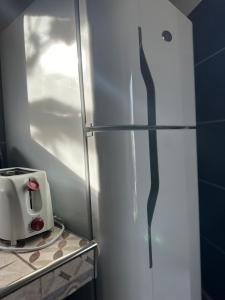 a kitchen with a refrigerator with a toaster on a counter at 3H MALARGUE Monoambiente in Malargüe +5 photos