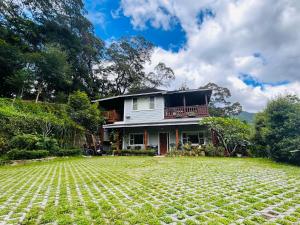 a house with a large yard in front of it at Hngaw Homestay in Xiayun