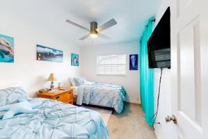 een slaapkamer met twee bedden en een flatscreen-tv bij Spacious 4 bedroom 3 bath Clearwater Vacation House Cowboy Pool Fire Pit Games Close to Clearwater Beach Biking Trail Farmers Markets Harbor Health Spa Baycare Ballpark and Ruth Eckerd Hall Golf Courses in Clearwater
