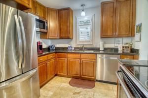 a kitchen with wooden cabinets and a stainless steel refrigerator at Pono Kai Resort #A101 - A Welcoming 2 Bdrm - 2 Bath, Private Beachfront Vacation Home in Kapaa
