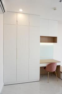 a white office with a desk and a pink chair at Modern 2BR Condo at Terra Royal by Orli Studio F21 in Ho Chi Minh City
