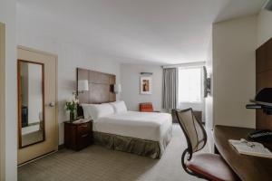 旧金山Club Quarters Hotel Embarcadero, San Francisco的一间带床和镜子的酒店房间