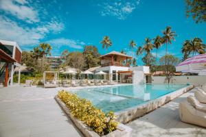 ein Pool in einem Resort mit Palmen in der Unterkunft Luxtalay Khanom Hotel in Khanom