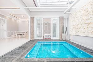 a swimming pool in the middle of a room with a table at Desa Residence Denpasar in Kerobokan