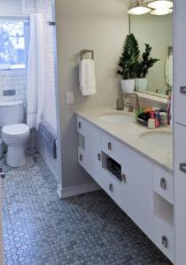 a bathroom with two sinks and a toilet and a mirror at Spacious and Elegant Space with Premium Kitchen that is Ideal for Gathering with Friends and Family in Middleton +5 photos