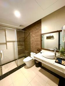 a bathroom with a toilet and a shower and a sink at Silk River Hotel Ha Giang in Ha Giang