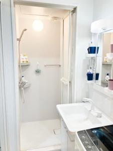 a white bathroom with a shower and a sink at Ueno Yuyuhouse 1Room for rent, Close to Senso-ji Temple,Kaminarimon Gate,Kappabashi Dougu Street,Akihabara,Shinjuku and Disneyland in Tokyo