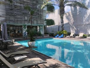 a swimming pool with chaise lounge chairs and a resort at The Double View Mansions Bali in Canggu