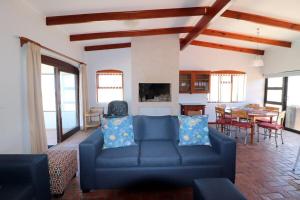 un salon avec un canapé bleu et une table dans l'établissement Naude House In Struisbaai, à Struisbaai