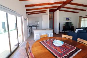 Il comprend un salon avec une table en bois et une cuisine. dans l'établissement Naude House In Struisbaai, à Struisbaai