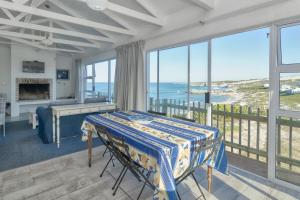 Un dormitorio con una cama y un balcón con vista al mar. en Stunning Seaviews - Arniston, en Arniston 24 fotos más