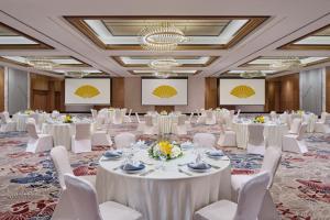 a ballroom with white tables and white chairs at Mandarin Oriental, Jakarta in Jakarta
