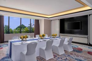 a conference room with a table and chairs and a flat screen tv at Mandarin Oriental, Jakarta in Jakarta