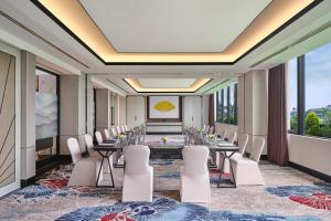 a conference room with a long table and white chairs at Mandarin Oriental, Jakarta in Jakarta