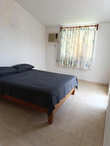 - une chambre avec un lit doté d'une couverture noire et d'une fenêtre dans l'établissement Casa Victor Manuel, à La Sabana