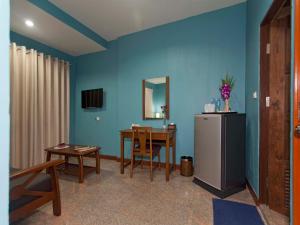a living room with a table and a refrigerator at Pattaya Garden Apartments Boutique Hotel in Pattaya South