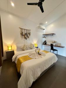 a bedroom with a large bed with a ceiling fan at RVilla El Nido in El Nido