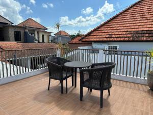 a patio with two chairs and a table on a balcony at Black Pillow Villa in Jimbaran