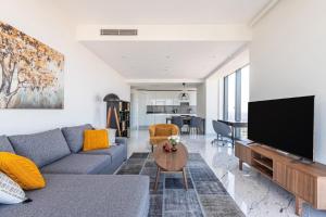 a living room with a couch and a flat screen tv at Beautiful Bright Deluxe 1bd Condo Poolviews! #311 in Istanbul