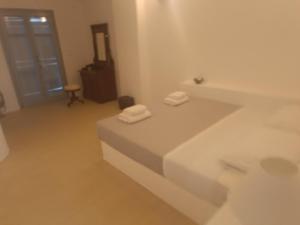 a white room with two towels sitting on a bed at Minos Villa Antiparos in Antiparos