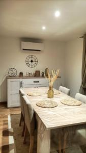 a dining room with a table with chairs and a clock at Gîte du Maron in Mâron +9 photos