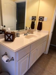 a bathroom with a sink and a large mirror at Farmhouse Charm in College Station +16 photos