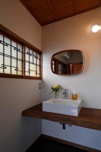 a bathroom with a white sink and a mirror at お宿 山本 in Iwadate