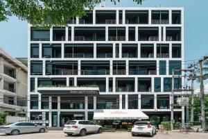 a white building with cars parked in front of it at Blu Monkey Hub and Hotel Phuket Town- Free All Day Coworking space in Phuket Town