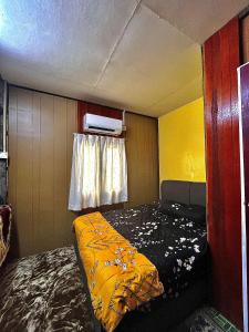 a small room with a bed and a window at Homestay Rumah Kayu Kota Tinggi in Johor Bahru