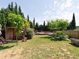 un cortile con una recinzione in legno e una panca di legno di Villa in Sant Mori with Pool near Dalí Museum a Sant Mori
