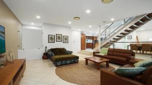 a living room with two couches and a table at Alemar Close To Beach, Shops and Cafes Accom Holidays in Avoca Beach