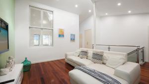 a living room with a white couch and a window at Alemar Close To Beach, Shops and Cafes Accom Holidays in Avoca Beach