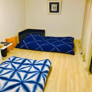 a bedroom with a blue bed and a wooden floor at Room 202 / Vacation STAY 13909 in Tokushima
