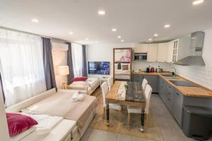 a kitchen and living room with a table and a couch at Monbuhim Premier in Veszprém