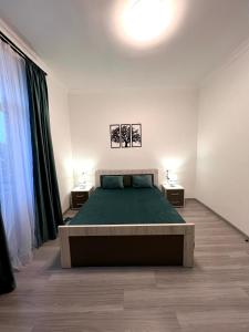 a bedroom with a bed and two lamps on two tables at Luxe Apartment Komitas in Yerevan