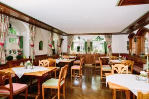 ein Restaurant mit Holztischen und -stühlen und Fenstern in der Unterkunft Hotel Jungbräu in Abensberg