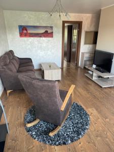 una sala de estar con un sofá y una silla en Grau Apartments 26, en Pärnu 12 fotos más