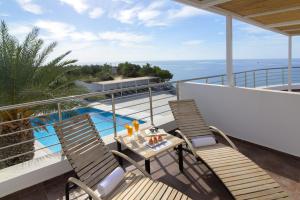 a balcony with two chairs and a table and a pool at Porto Belissario in Ferma
