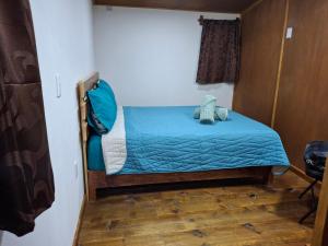 a small bed in a room with a blue blanket at Cabañas De La Vega in Tomatlán