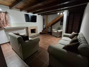 a living room with two couches and a fireplace at Cabañas De La Vega in Tomatlán