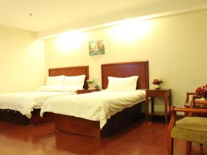 a bedroom with two beds with white sheets and pillows at GreenTree Inn Zhejiang Zhoushan Xincheng Business Hotel in Zhoushan