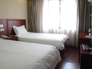 a hotel room with two beds and a window at GreenTree Inn Zhejiang Zhoushan Xincheng Business Hotel in Zhoushan