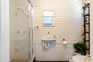 Un baño blanco con lavabo y ducha. en Oasis On Rice Street Downstairs, en Rockhampton 5 fotos más