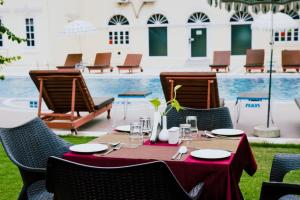 a table with a red table cloth and chairs and a pool at Hotel Surya, Kaiser Palace in Varanasi