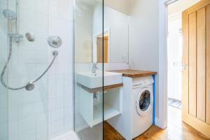 a bathroom with a sink and a washing machine at Little Park Farm Queen Anne Farmhouse & Apartments in Stratfield Mortimer