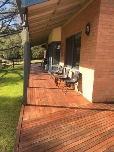 a group of chairs sitting on a wooden deck at Yarrabin Country Retreat in OʼConnell