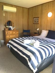 a bedroom with a large bed and a wooden wall at Yarrabin Country Retreat in OʼConnell