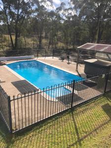 a fence around a swimming pool in a yard at Yarrabin Country Retreat in OʼConnell